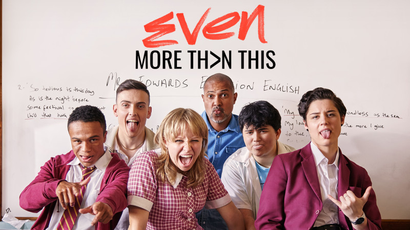 A group of six young people poses playfully in front of a whiteboard with handwritten text. They are making funny faces, with some sticking out their tongues and others smiling widely, showcasing a vibrant and energetic atmosphere.