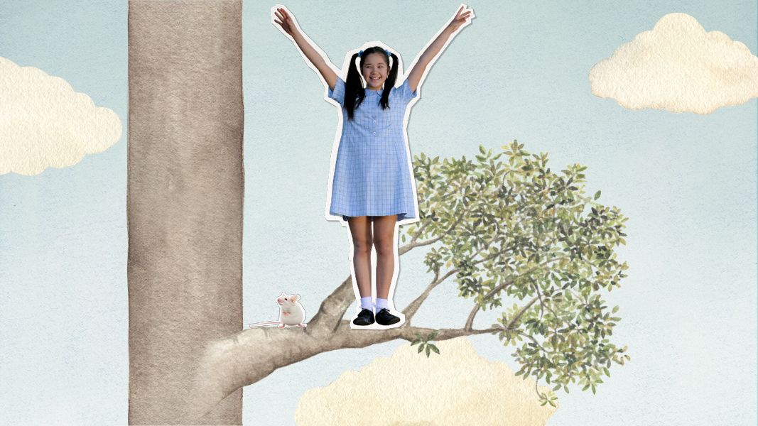 A young girl in a blue dress stands triumphantly on a branch of a tree, with her arms raised high. A small white mouse sits nearby on the same branch, and fluffy clouds decorate the pastel sky.