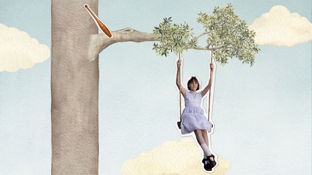 A girl in a pale blue dress swings joyfully from a tree branch, surrounded by a whimsical background of light blue sky and soft clouds. A baseball bat is placed above her on the tree, enhancing the playful scene.