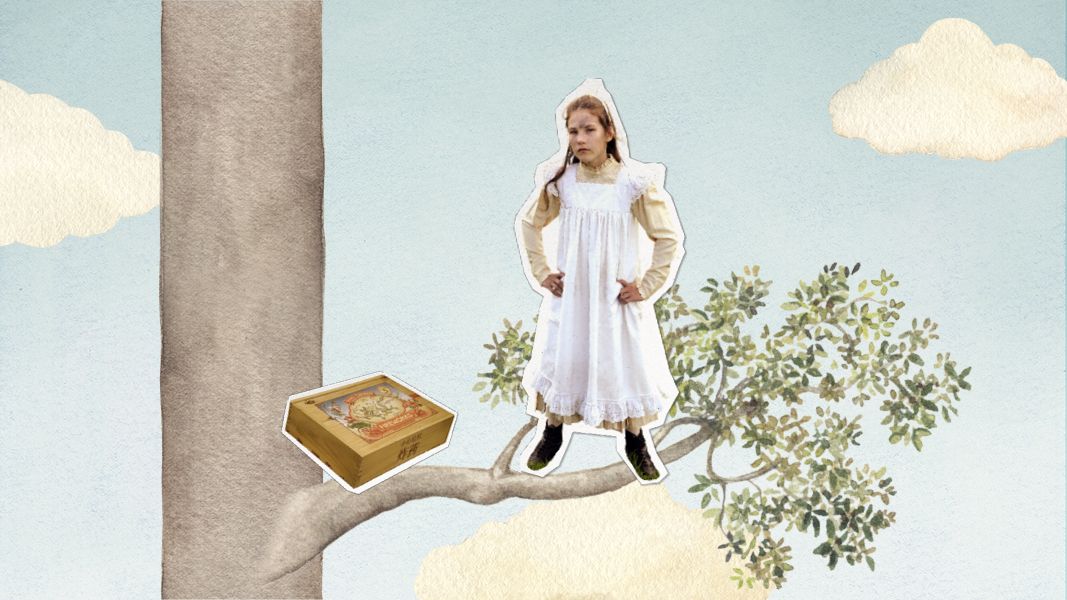 A young girl in a white dress stands confidently on a branch of a tree, with her hands on her hips and a serious expression. Beside her on the branch is a brightly decorated box, and the sky in the background is light blue with fluffy white clouds.